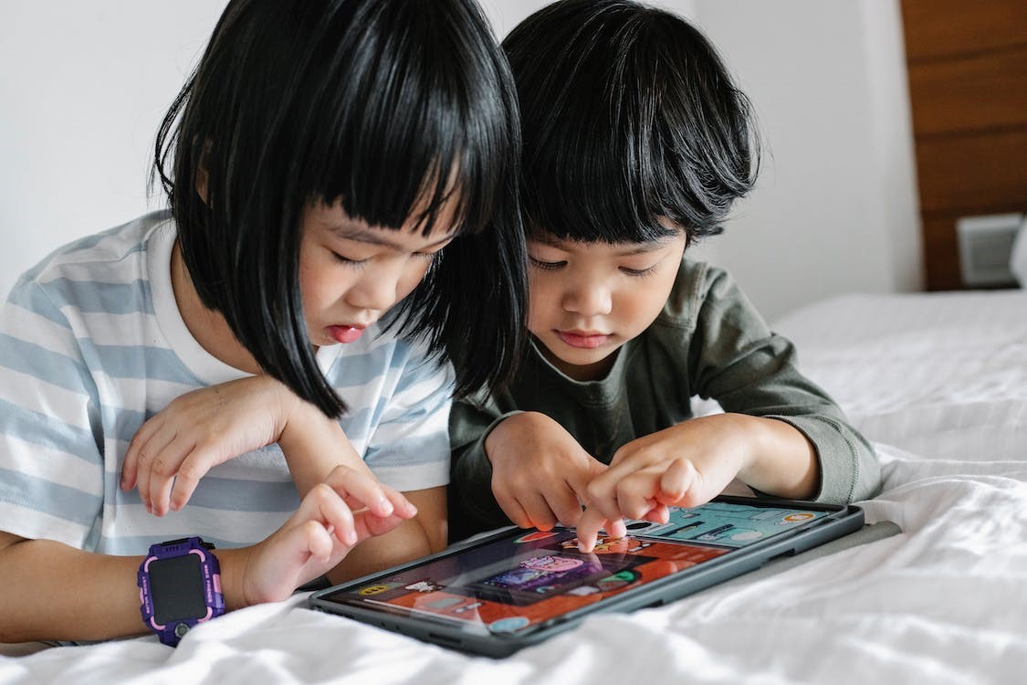 Dos niños juegan con una pizarra electrónica