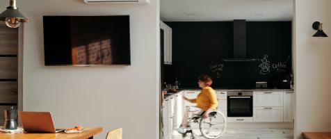 Mujer en silla de ruedas mpoviéndose por una cocina