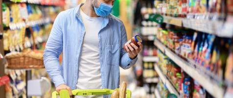 Un hombre mira el etiquetado de un alimento en el supermercado